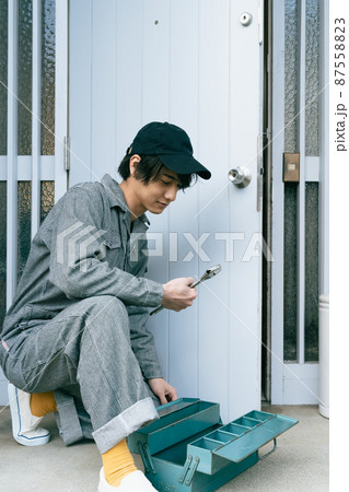 ドアを修理する若い男性 ドアを修理する若い男性 87558823