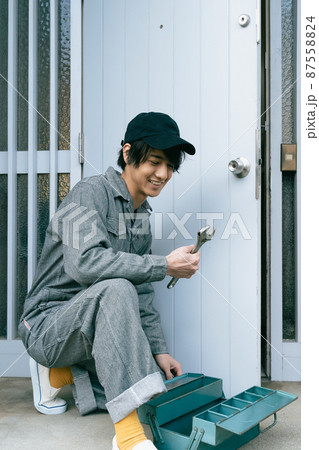 ドアを修理する若い男性 87558824