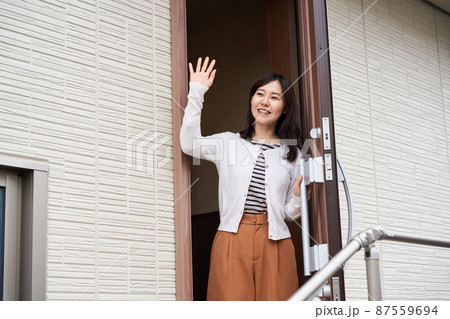 行ってらっしゃいをする女性 87559694
