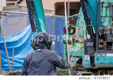 雨の中、建設工事をする作業員 87559837