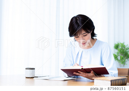 リビングで勉強する若い女性 87560151