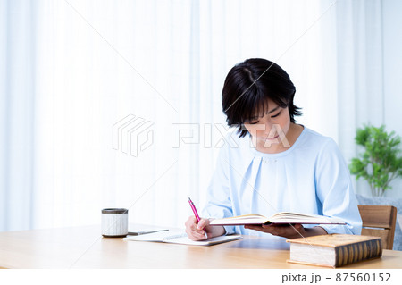 リビングで勉強する若い女性 87560152