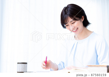 リビングで勉強する若い女性 87560159
