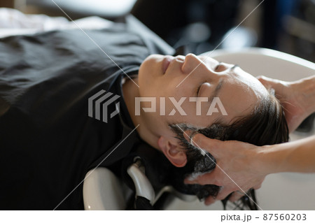 美容室でシャンプーしてもらう男性 美容室でシャンプーしてもらう男性 87560203