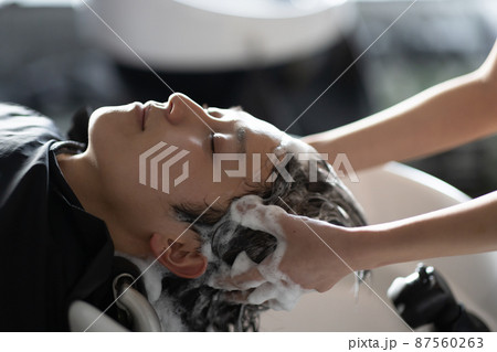 美容室でシャンプーしてもらう男性 87560263