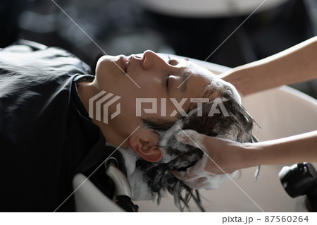 美容室でシャンプーしてもらう男性 87560264
