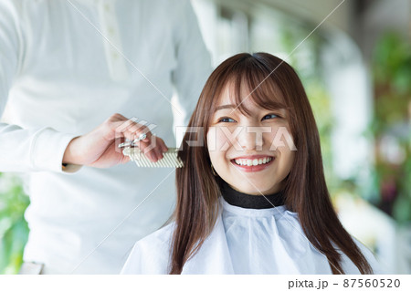 美容院でヘアカットしてもらう女性 87560520