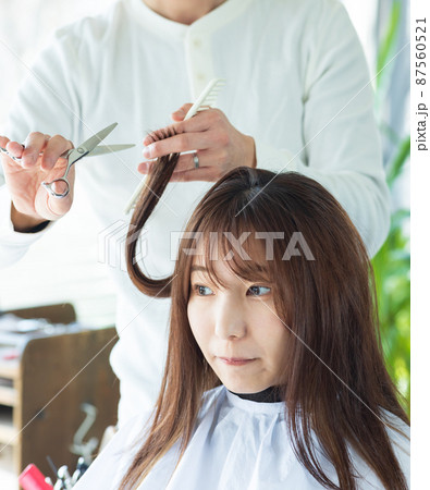 美容院でヘアカットしてもらう女性 87560521
