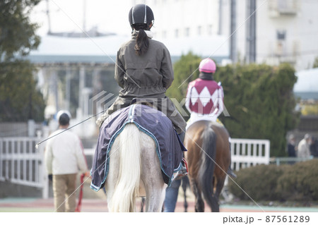 競馬場　誘導馬に乗る女性 87561289