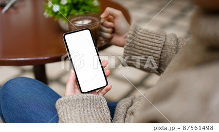 Smartphone white screen mockup in a woman's hand Smartphone white screen mockup in a woman's hand 87561498