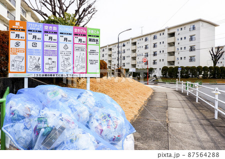 団地内のゴミ収集場所越しに見る築古の集合住宅 87564288