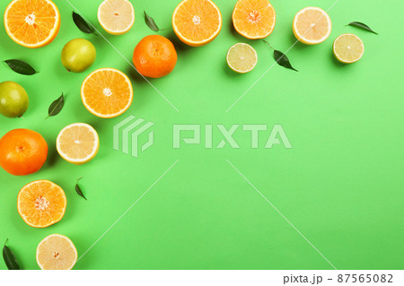Flat lay composition with tangerines and different citrus fruits on green background. Space for text Flat lay composition with tangerines and different citrus fruits on green background. Space for text 87565082