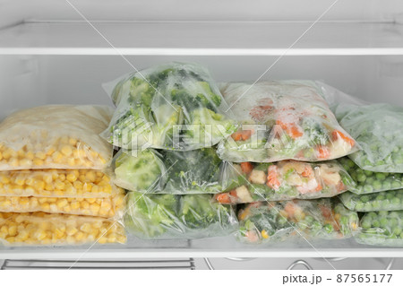 Plastic bags with different frozen vegetables in refrigerator Plastic bags with different frozen vegetables in refrigerator 87565177