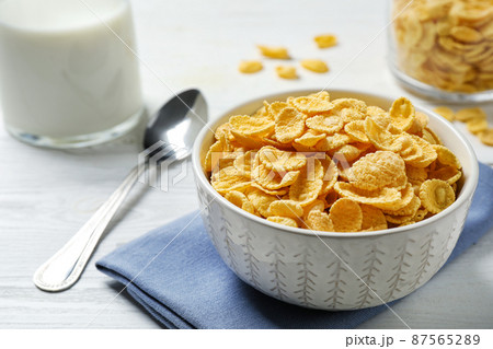 Tasty corn flakes on white wooden table Tasty corn flakes on white wooden table 87565289