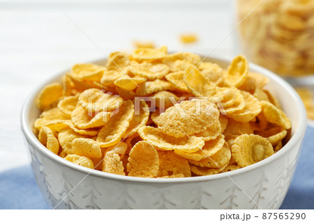 Tasty corn flakes on white table, closeup Tasty corn flakes on white table, closeup 87565290