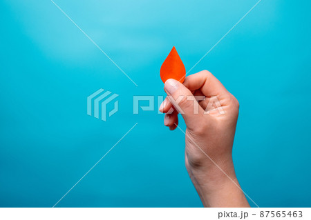 Blood donation. Human hand holding blood drop symbol on a blue background with copy space. World blood donor day and save life Blood donation. Human hand holding blood drop symbol on a blue background with copy space. World blood donor day and save life 87565463