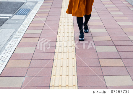 点字ブロックと歩いている女性の足 87567755