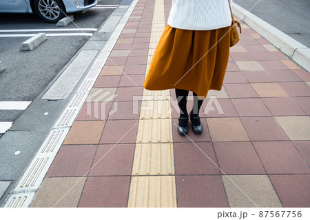 点字ブロックと歩いている女性の足 点字ブロックと歩いている女性の足 87567756
