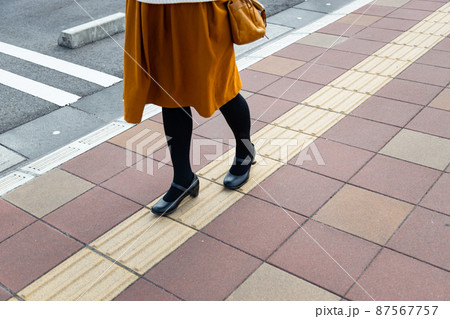 点字ブロックと歩いている女性の足 点字ブロックと歩いている女性の足 87567757