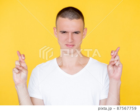 Good luck. Faithful man. Hopeful believes. Handsome concentrated guy crossing fingers asking wish come truth isolated yellow. Good luck. Faithful man. Hopeful believes. Handsome concentrated guy crossing fingers asking wish come truth isolated yellow. 87567759