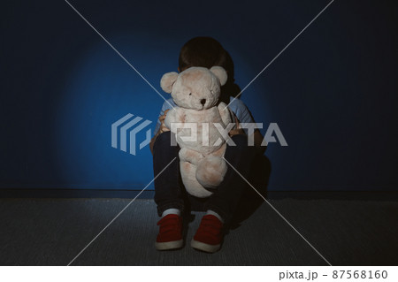Little boy with teddy bear near blue wall. Domestic violence concept 87568160
