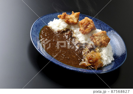 福神漬けも乗っている熱々唐揚げカレーを黒背景で撮影 87568627