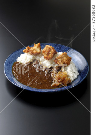 福神漬けも乗っている熱々唐揚げカレーを黒背景で撮影 福神漬けも乗っている熱々唐揚げカレーを黒背景で撮影 87568632