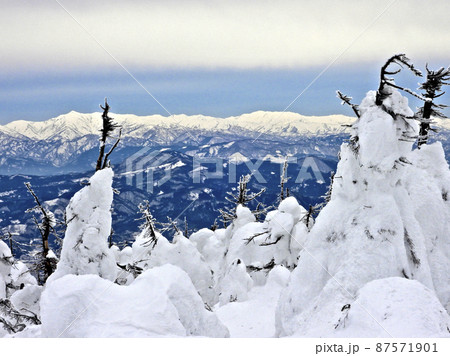 山形県蔵王 地蔵岳の樹氷原の彼方に聳える朝日連峰とヘリコプター 山形県蔵王 地蔵岳の樹氷原の彼方に聳える朝日連峰とヘリコプター 87571901