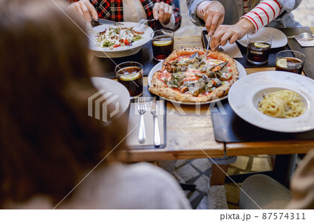 Friendly company enjoying delicious food in restaurant Friendly company enjoying delicious food in restaurant 87574311