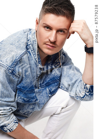 handsome young man in Jean jacket on white background 87579238