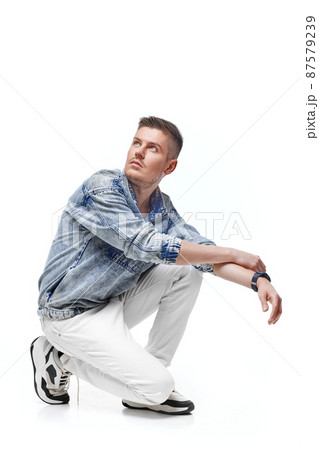 handsome young man in Jean jacket on white background 87579239