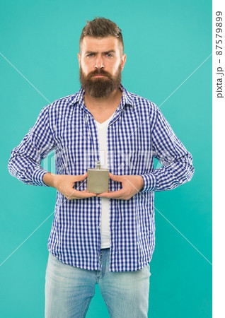 mature male hipster using perfume fragrance from bottle on blue background, advertisement mature male hipster using perfume fragrance from bottle on blue background, advertisement 87579899