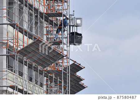 とび職　メッシュシートを電動昇降機で荷揚げ作業 87580487