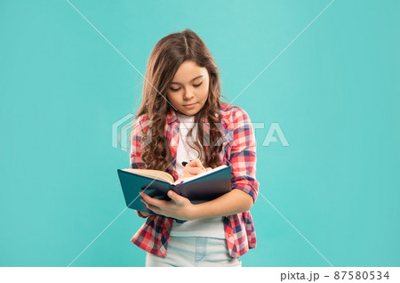 serious teen girl make notes on blue background, education serious teen girl make notes on blue background, education 87580534