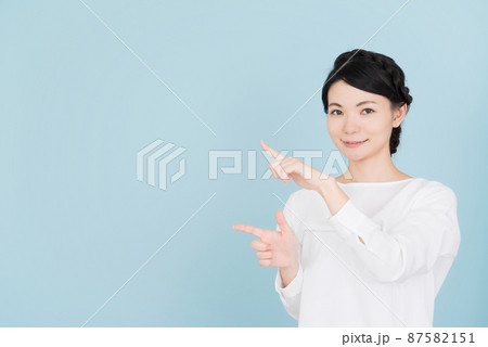 指で指し示す白いブラウスを着た女性 指で指し示す白いブラウスを着た女性 87582151