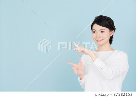指で指し示す白いブラウスを着た女性 指で指し示す白いブラウスを着た女性 87582152