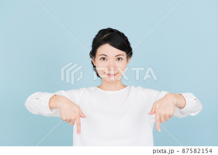 指で指し示す白いブラウスを着た女性 指で指し示す白いブラウスを着た女性 87582154