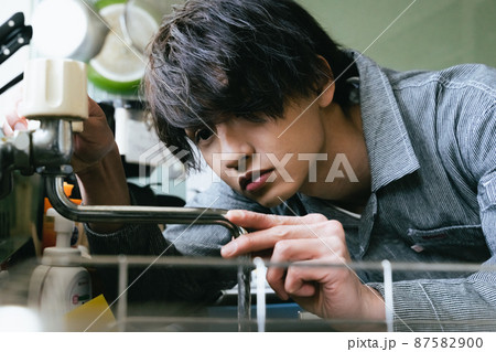 水道修理をする若い男性 87582900