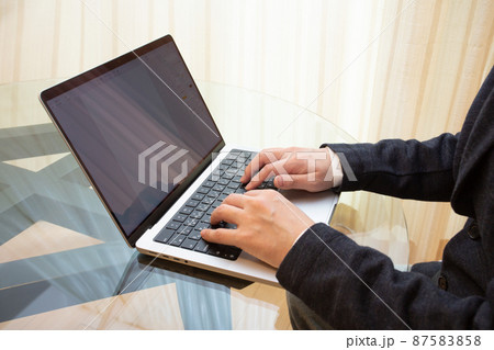 ノートパソコンのキーボードをタイピングしてビジネス書類を作成するスーツ姿の会社員 ノートパソコンのキーボードをタイピングしてビジネス書類を作成するスーツ姿の会社員 87583858