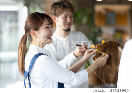 パーマの練習をする若いスタッフ 87583949