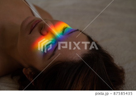 Close-up portrait of caucasian woman with ray of rainbow light on her face. Close-up portrait of caucasian woman with ray of rainbow light on her face. 87585435