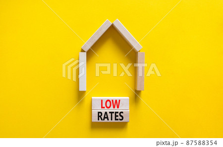 Low house rates symbol. Concept words 'Low rates' on wooden blocks near miniature house. Beautiful yellow background, copy space. Business and low house rates concept. Low house rates symbol. Concept words 'Low rates' on wooden blocks near miniature house. Beautiful yellow background, copy space. Business and low house rates concept. 87588354