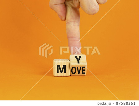 Make my move symbol. Businessman turns the wooden cube with words 'My move'. Beautiful orange background. Make my move and business concept. Copy space. 87588361