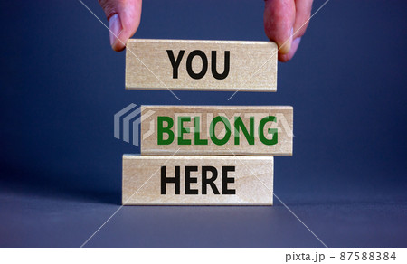 You belong here symbol. Wooden blocks with words 'You belong here' on beautiful grey background. Male hand. Diversity, business, inclusion and belonging concept. You belong here symbol. Wooden blocks with words 'You belong here' on beautiful grey background. Male hand. Diversity, business, inclusion and belonging concept. 87588384