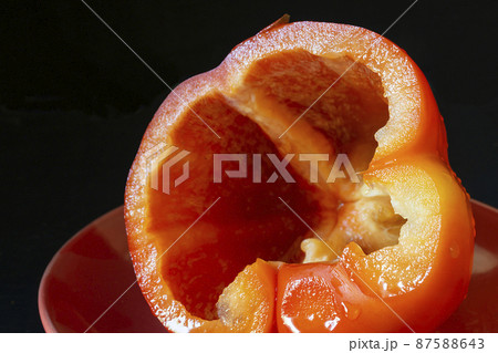 Cut red pepper in plate on black background 87588643