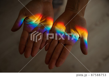 Rainbow ray on a woman's hand. Rainbow ray on a woman's hand. 87588753