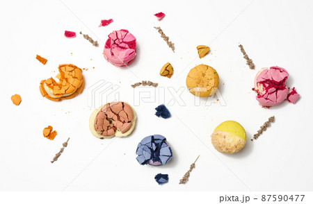 broken round macarons with crumbs on a white background, delicious dessert, top view 87590477