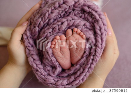 Small beautiful legs of a newborn baby in the first days of life Small beautiful legs of a newborn baby in the first days of life 87590615