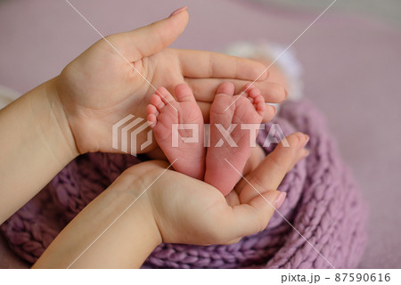 Small beautiful legs of a newborn baby in the first days of life Small beautiful legs of a newborn baby in the first days of life 87590616