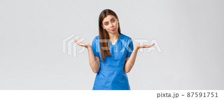 Healthcare workers, prevent virus, insurance and medicine concept. Indecisive and unsure cute nurse, doctor in blue scrubs, shrugging with hands sideways, pouting, dont know and cant tell 87591751
